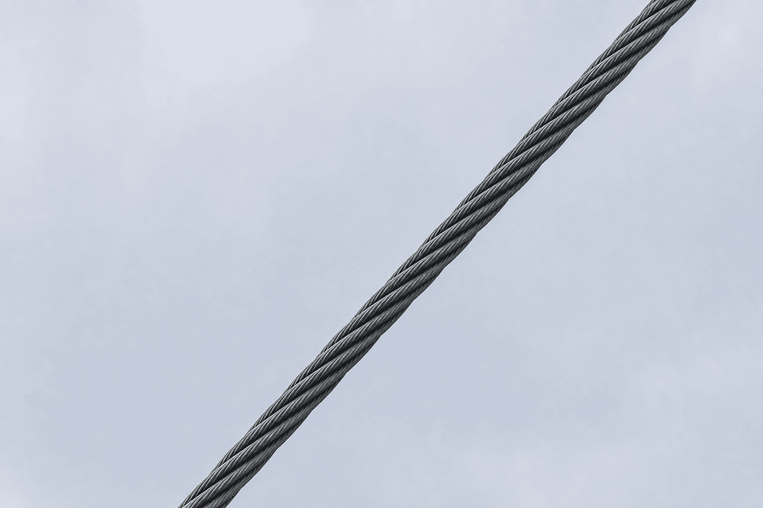 taut cable or cord against pale sky, clean geometric line